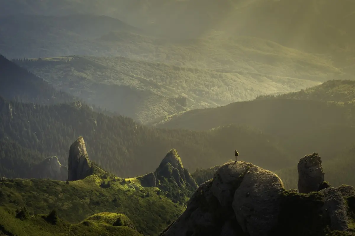 First light spilling across the misty Kenyan highlands, a lone figure standing on the ridge at dawn.